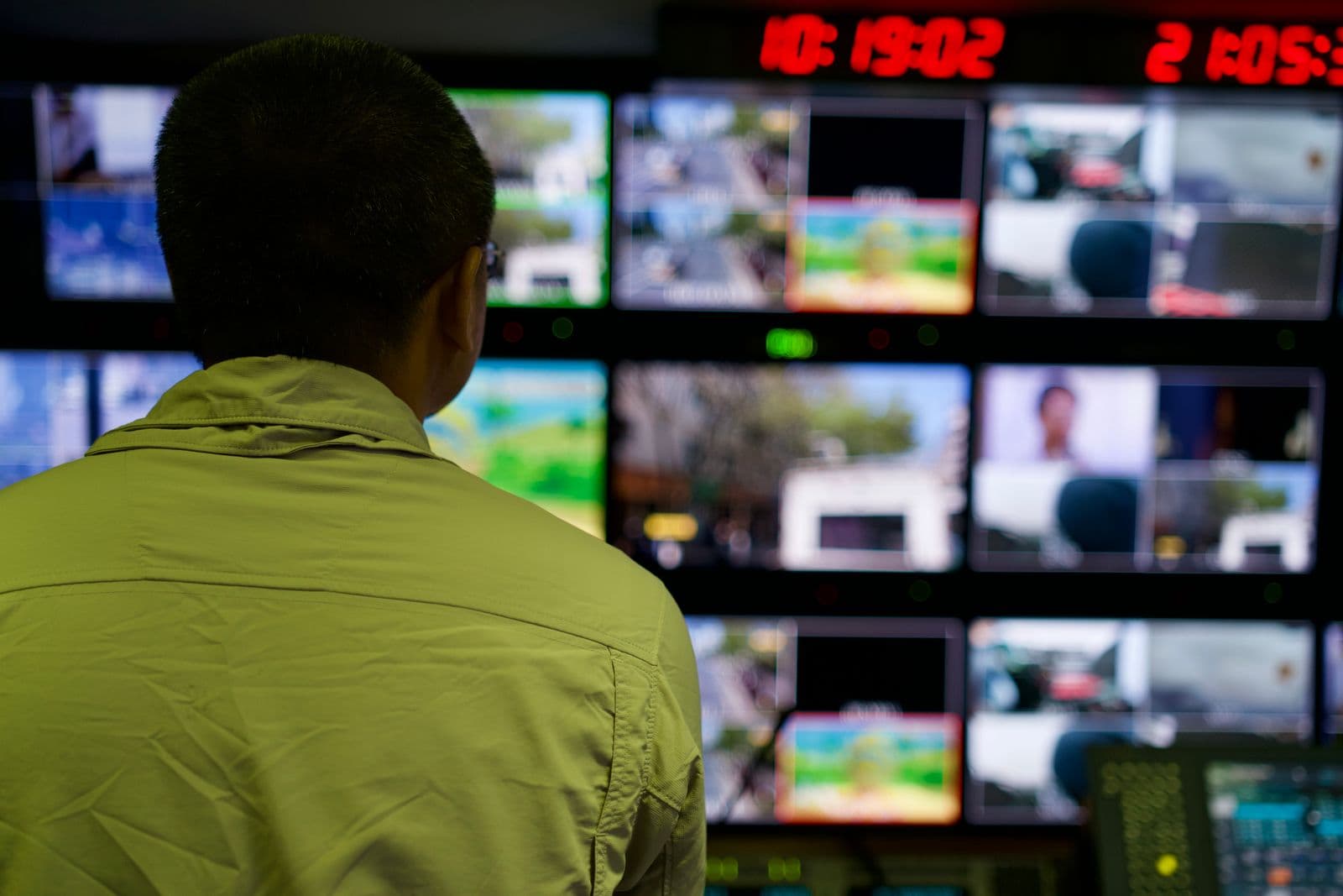 A dispatcher in a control room monitoring multiple live screens