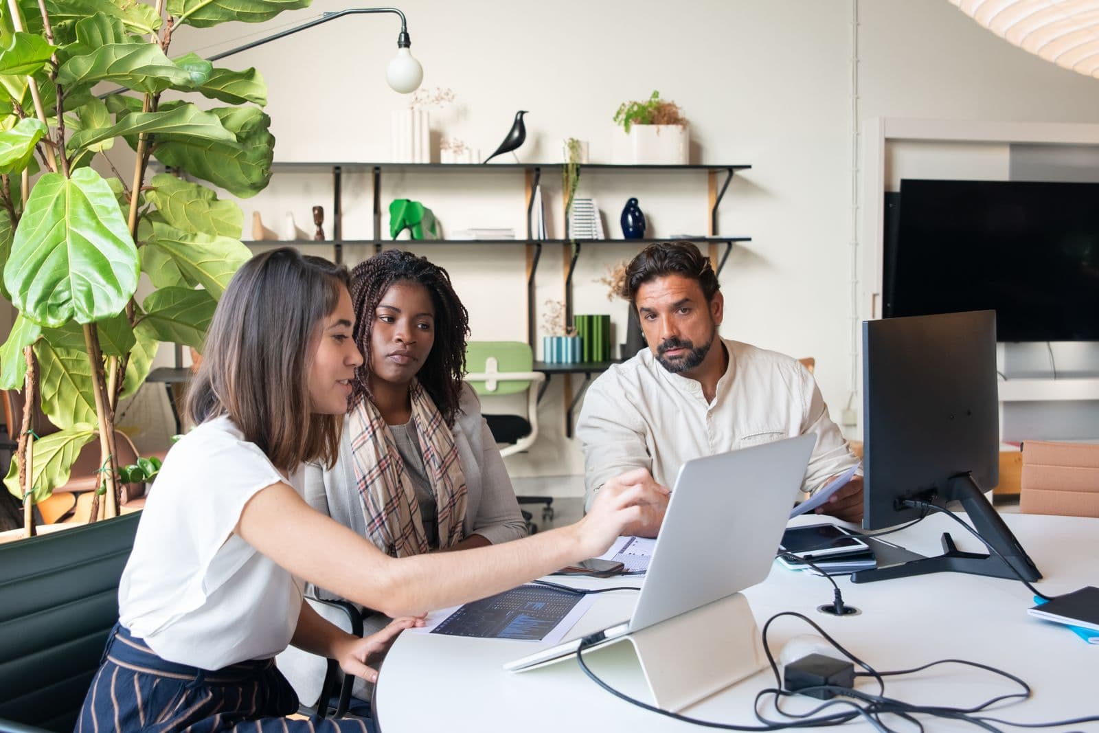 A team of colleagues reviewing options together around a laptop