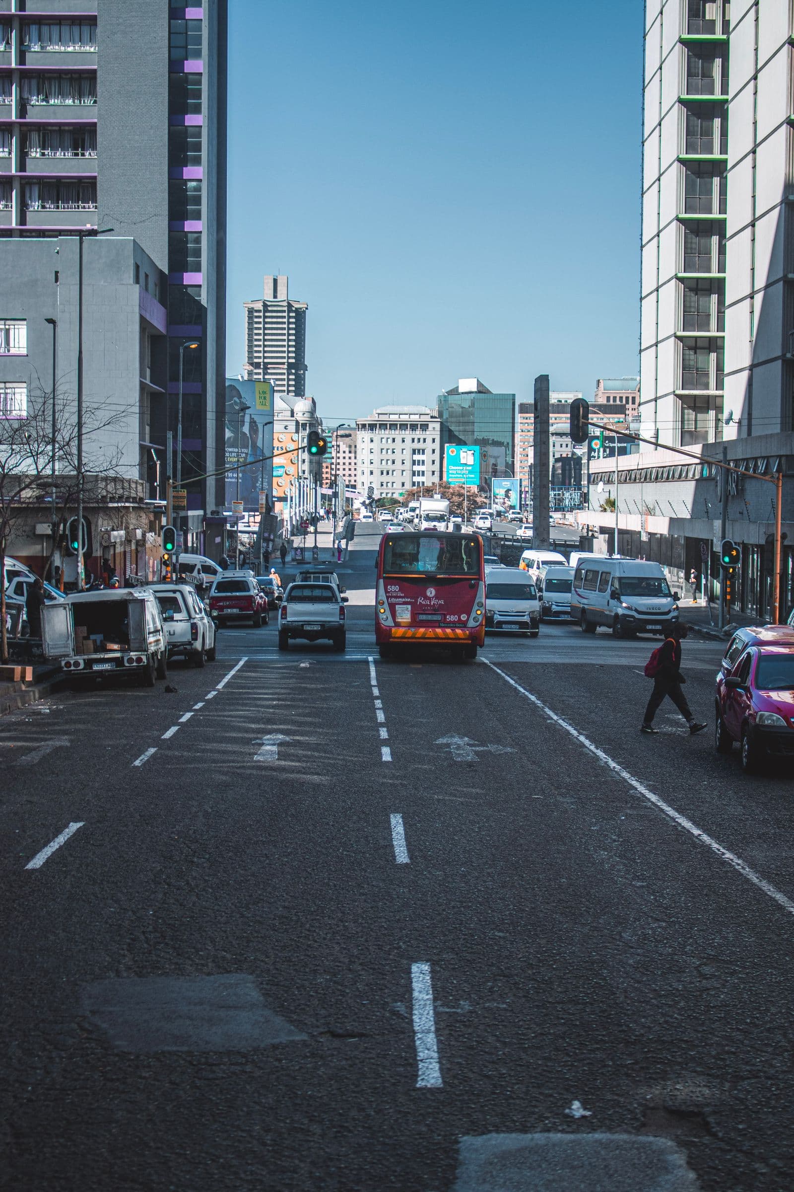 Rush-hour traffic on a busy Johannesburg street with a bus, vans, and cars