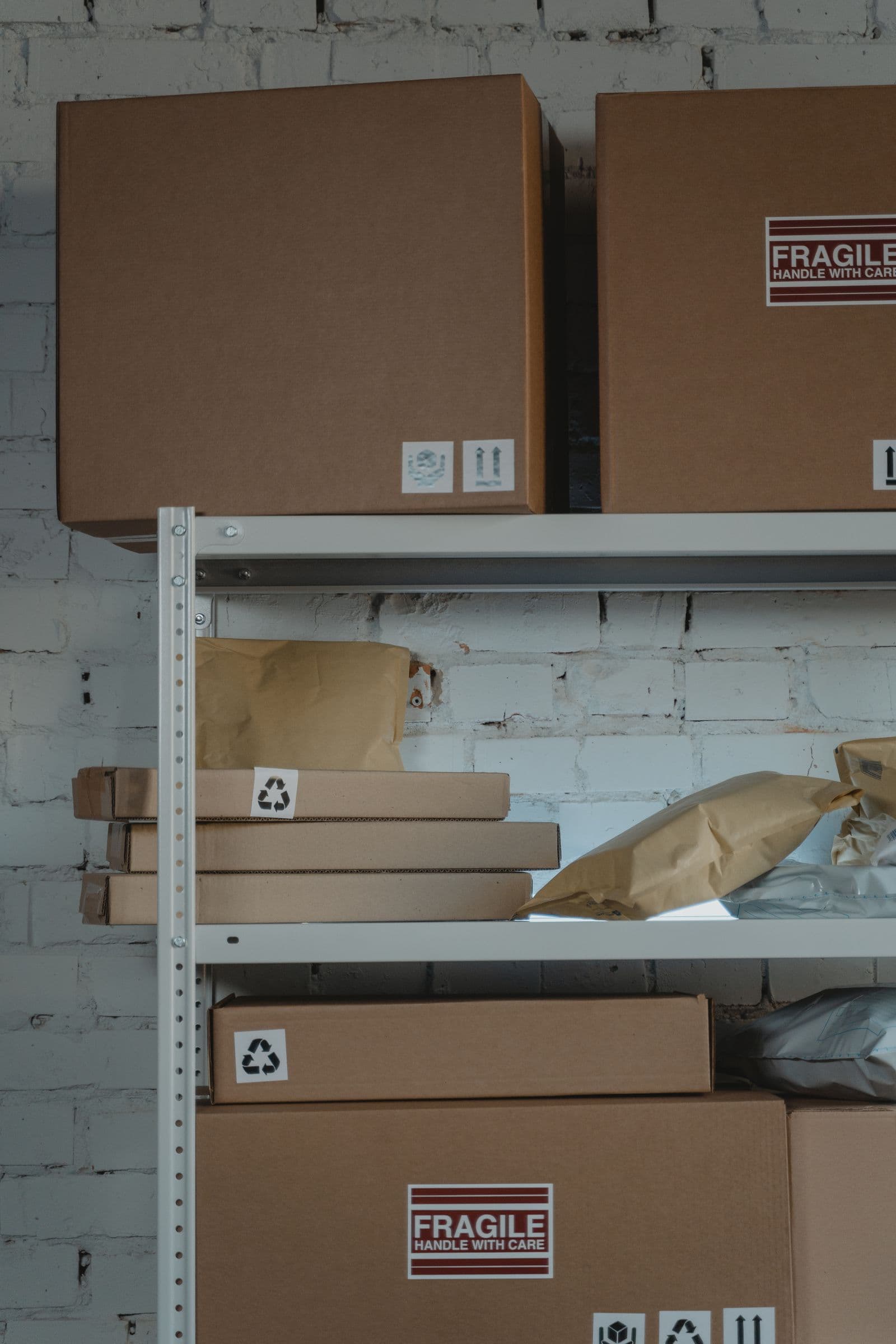 Shelves stocked with parcels, mailer bags, and boxes marked 'fragile'
