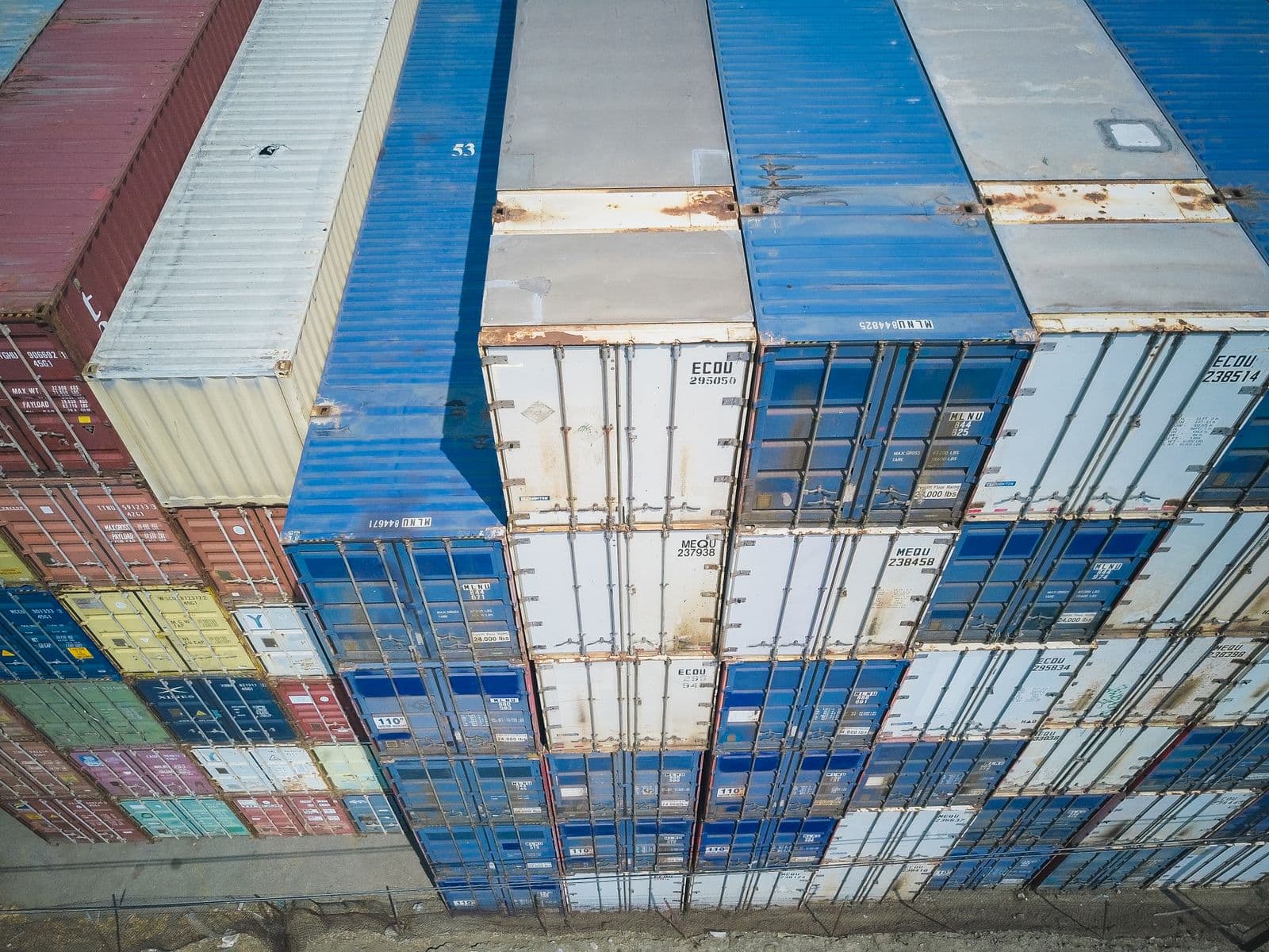 Aerial view of stacked, numbered shipping containers at a cargo yard